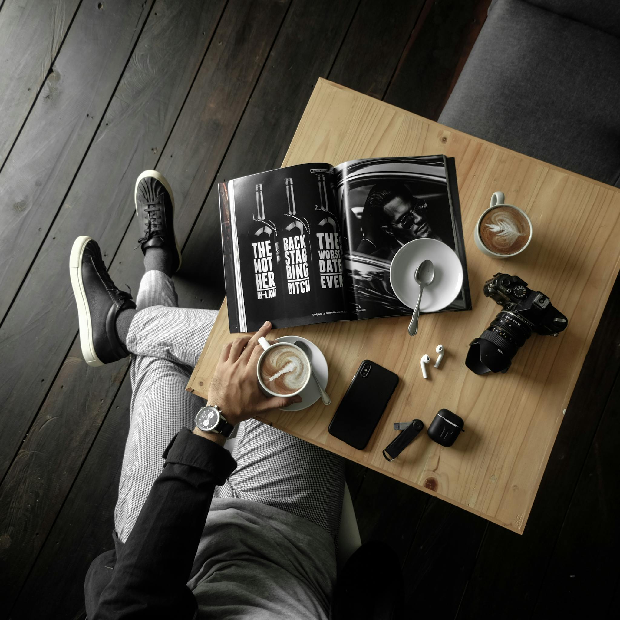 A stylish overhead view of a man enjoying coffee with gadgets on a wooden table.